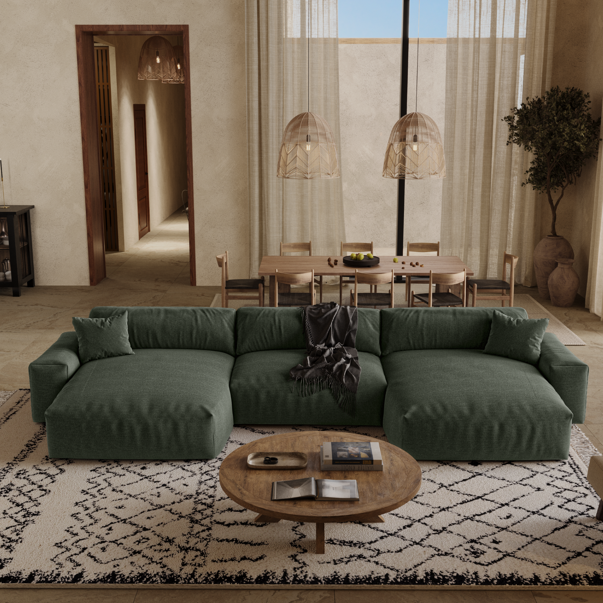 Canapé panoramique en tissu tramé vert émeraude, table basse ronde en bois et grand tapis à motifs, placés au centre d'un salon moderne